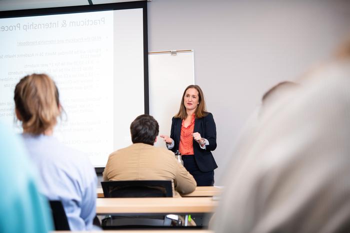 A Psychiatric Mental Health Nursing Educator teaching a room of students.